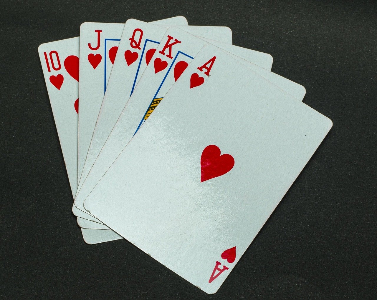Mesa de poker com flush draw de copas ilustrando as regras do Texas Hold'em na mão do dia