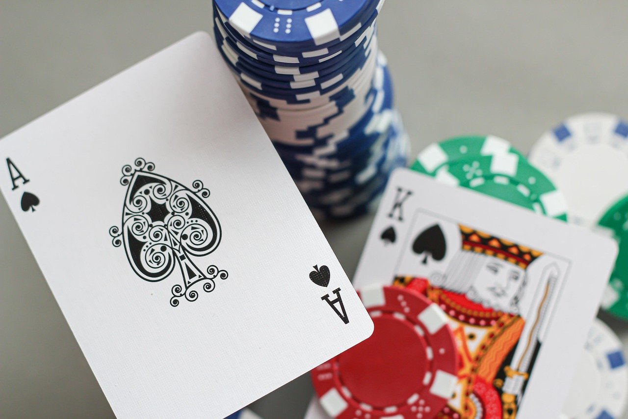 Mesa de poker com fichas empurradas no all-in ilustrando uma decisão de AJ suited com stack curto
